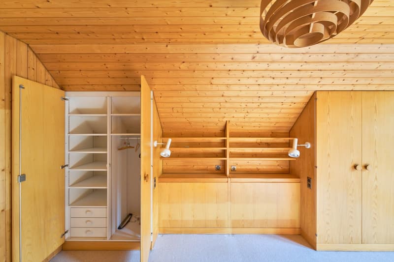 Wooden interior with shelves, storage cabinets, and a wooden ceiling with a unique light fixture