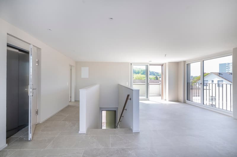 wide open space, gray tiled floor, sliding doors, balcony, staircase to lower floor