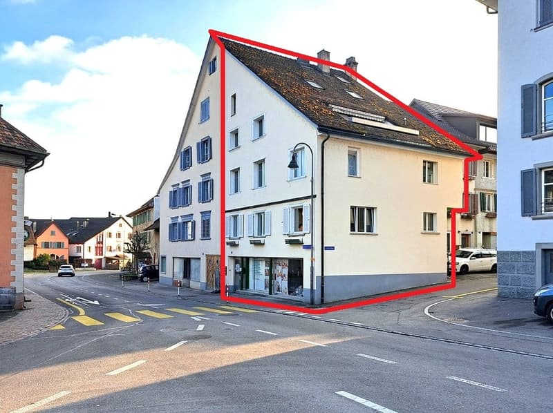Corner house, multiple windows, red roof, raised ground floor, street front
