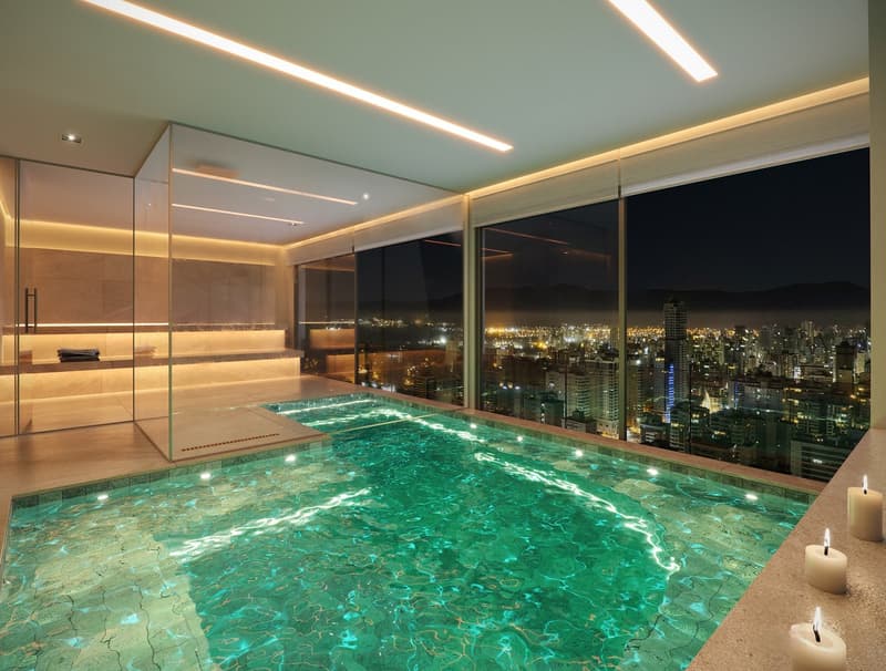 Indoor swimming pool with glass walls, city view, candles, modern design