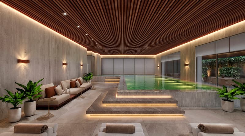 Indoor swimming pool, lounge area with couches, plants, and tables, wooden ceiling, and wall lighting