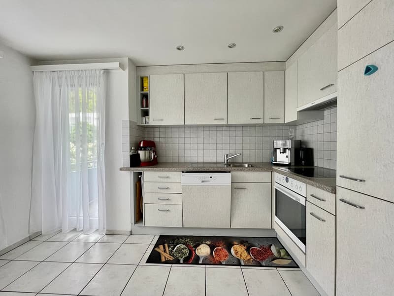 modern kitchen with white cabinets, tiled floor, dishwasher, washing machine, gas stove, sink, countertop, kitchen appliances