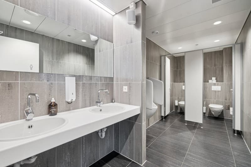 modern bathroom with two sinks, two urinals, and two toilets