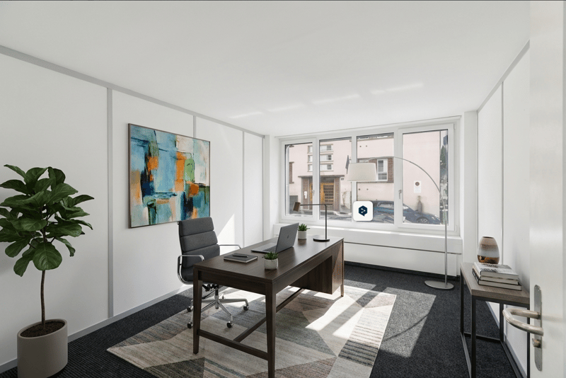 office room with desk, chair, painting, plant, lamp, books, laptop, and carpet