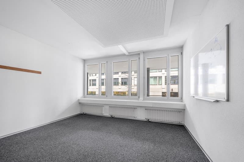 empty room, white walls, gray carpet, large windows, whiteboard on wall