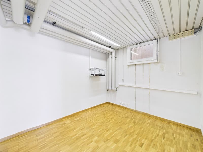 empty room, wooden floor, white walls, ceiling mounted lights, pipe installation on wall