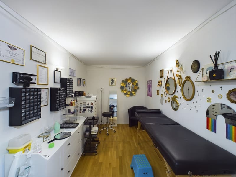Office room with black furniture, multiple white cabinets, mirror, white walls, wooden floor, stool