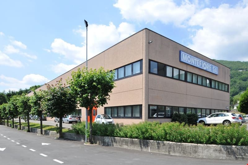 Commercial building, multiple windows, multiple cars parked in front