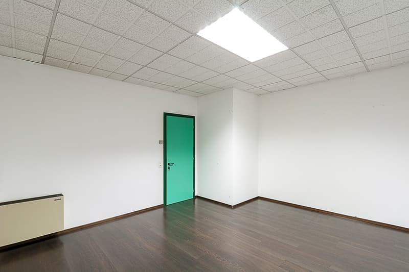 room, wooden floor, white walls, green door, central ceiling light, white ceiling