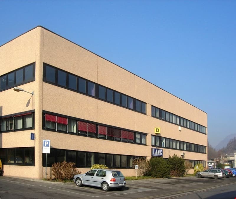 office building, beige facade, multiple floors, several windows, parking lot
