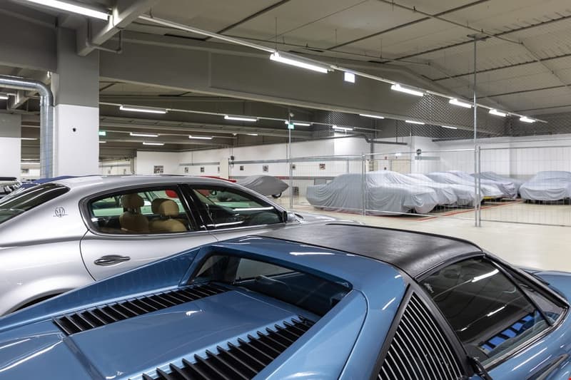 large garage, multiple cars parked, metal fences, covered cars