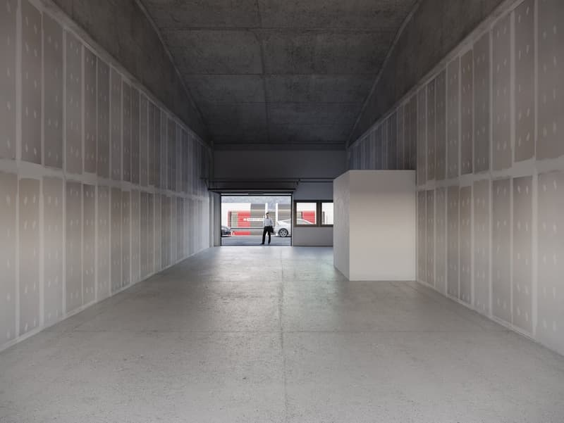 Empty room with concrete floor, walls, and ceiling, open door leading to a garage with cars parked