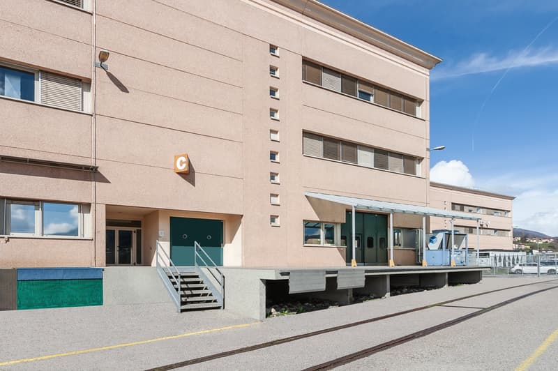 Concrete building with 5 floors, entrance with stairs, windows with blinds, parking on side