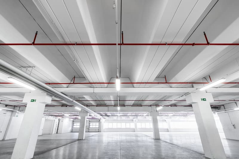 Spacious parking lot, multiple ceiling lights, two pillars on the sides