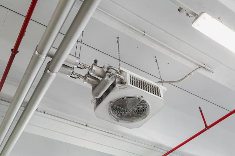 Suspended heating and cooling unit from ceiling with attached piping and chain