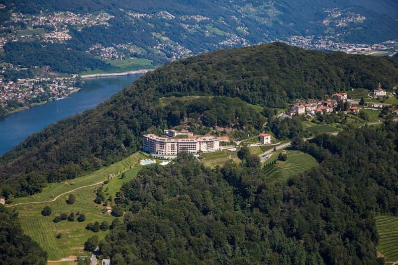 Hotel overlooking a valley with a river and a small town.