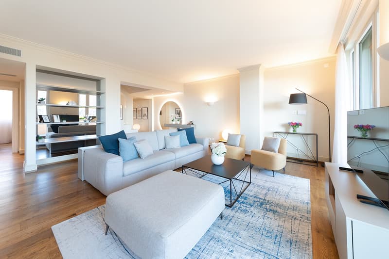 modern design, large couch, coffee table, ottoman, floor lamps, window with curtains, rug