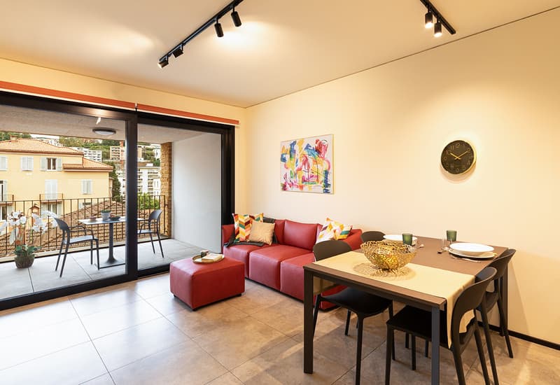 modern living room, red sofa, wooden dining table, white table runners, modern paintings, black modern chairs, sliding doors to the balcony, balcony with plants