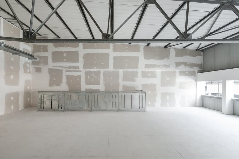 Empty room, unfinished walls, metal beams, white floor, metal structure in the middle