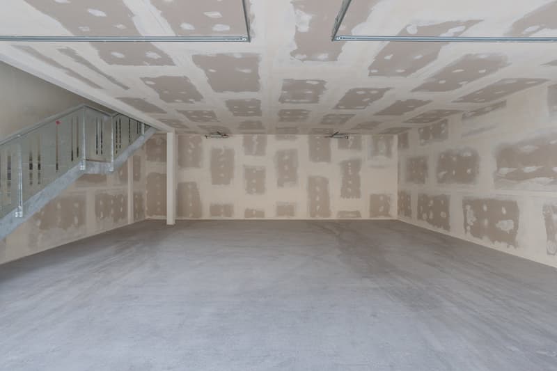 Empty room, concrete floor, unfinished walls, metal staircase