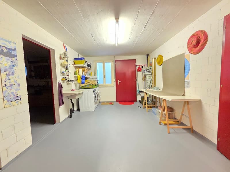 Laundry room with washing machine, shelves, a sink, and a door leading to a utility room