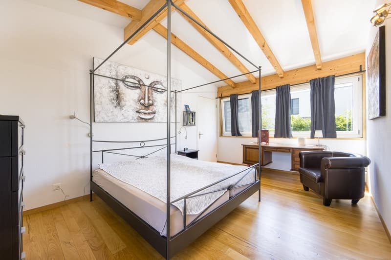 Schlafzimmer mit hohen Räumen und viel natürliches Licht