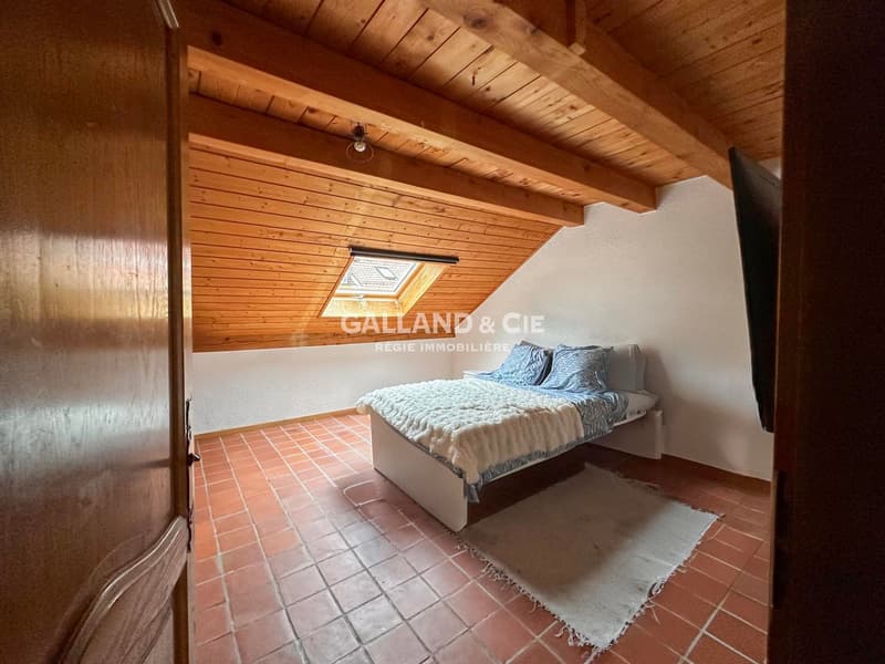 bedroom with wooden beam ceiling, double bed, small carpet, skylight window, wall mounted light
