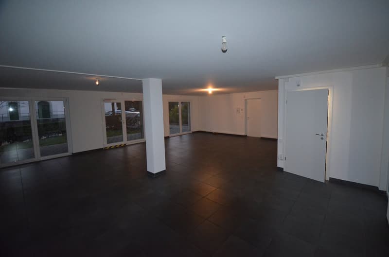 spacious empty room with sliding doors, tiled floor, and ceiling lights
