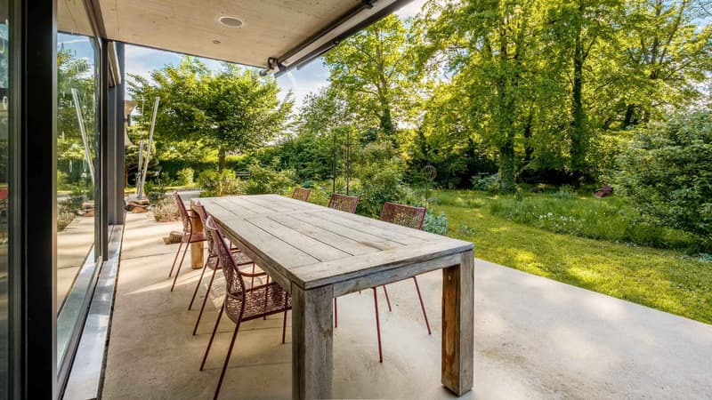 Terrasse en extention de la cuisine et son jardin joliment arboré