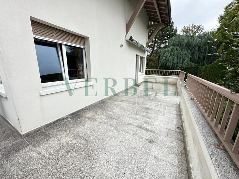 / a large balcony with a large window on the side of the house
