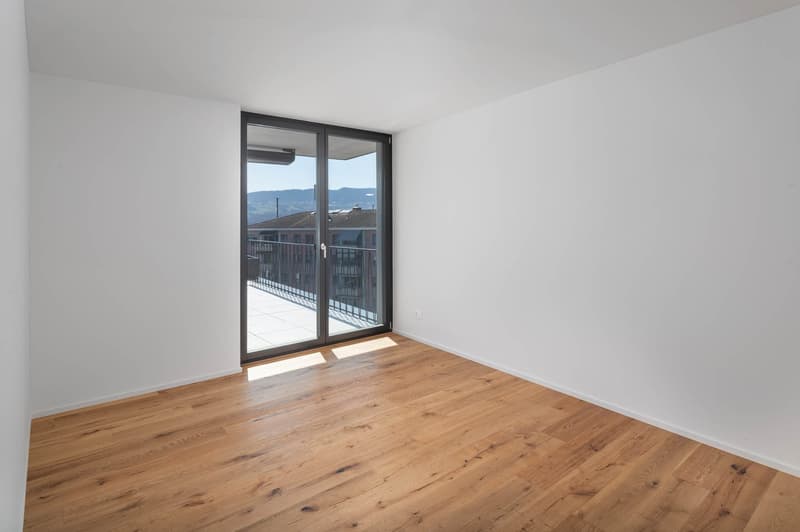 empty room, hardwood floor, sliding glass door, balcony, white walls, view of the city