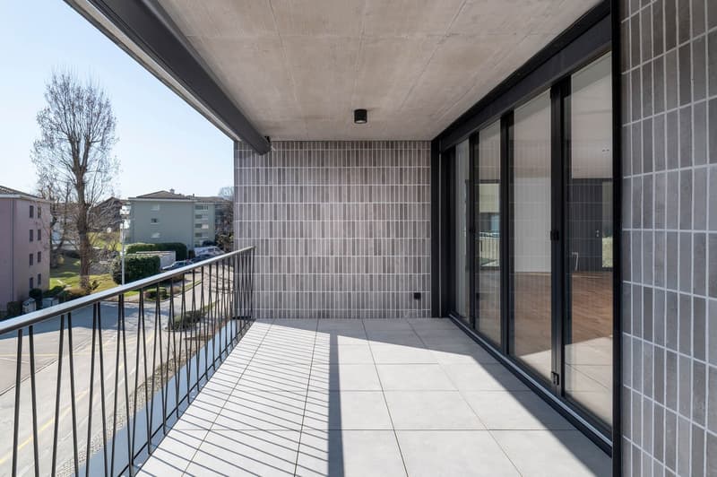 Balcony with tiled floor, metal railing, glass doors, and a view of the outside
