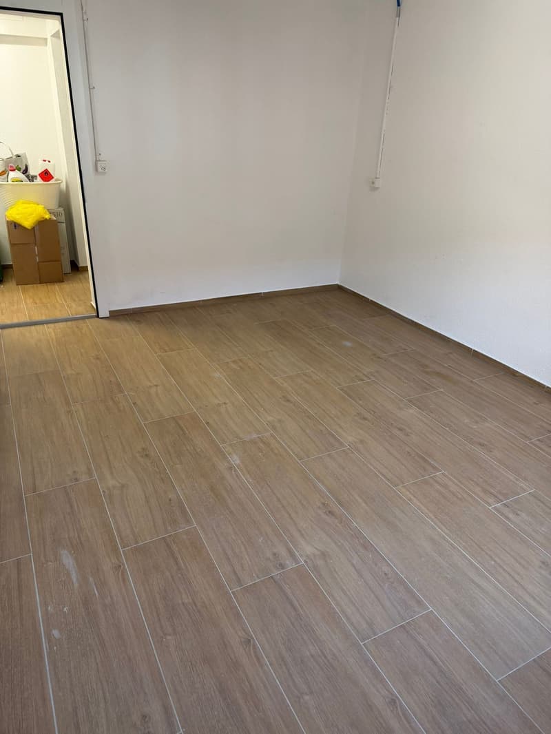 empty room, wooden floor, white walls, open door, storage boxes