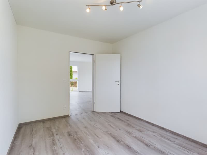 empty room, white walls, wooden floor, open door, hallway