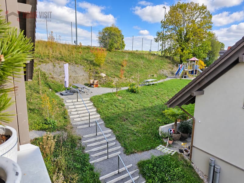 Grüne Umgebung mit Sitzplätzen und Spielplatz