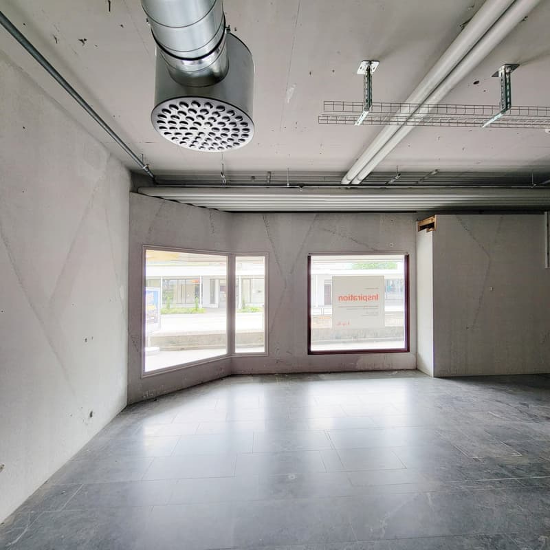 unfinished room with white wall and gray floor, two arched windows and one rectangular window, exhaust fan on the ceiling