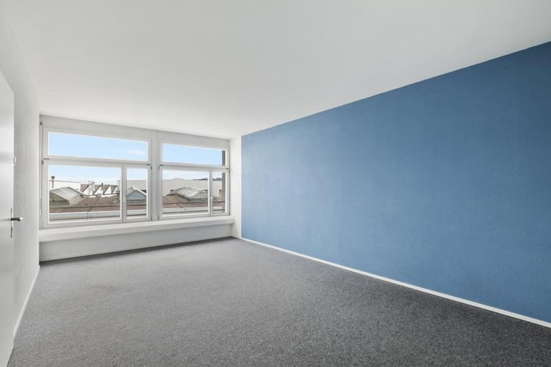large window, blue wall, gray floor