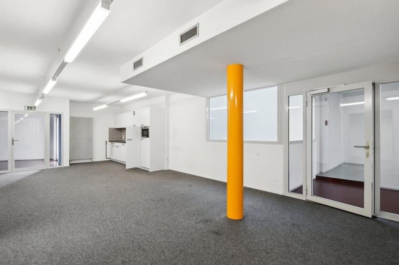 Empty room, white walls, gray floor, glass doors, yellow column, lights