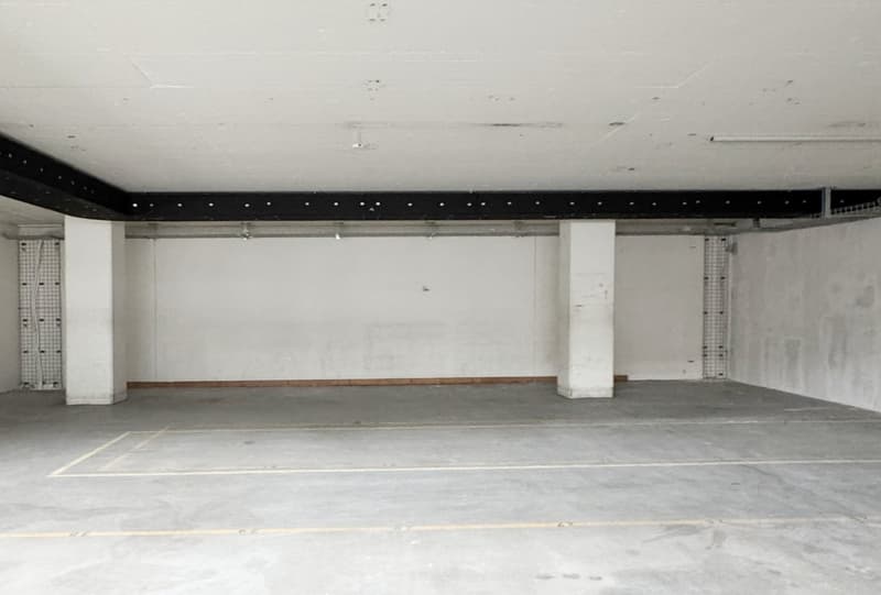 empty room, white walls, concrete floor, yellow lines, pillars