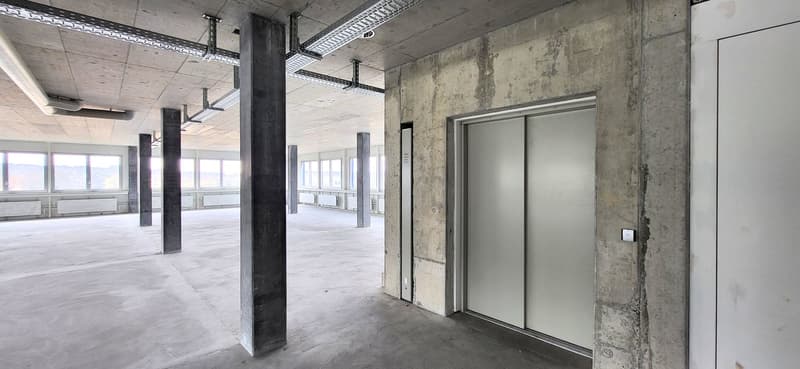 empty room, concrete walls, metal beams, elevator, windows