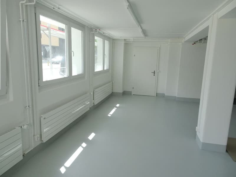 Empty room, white walls, white floor, 3 windows, 3 white radiators, 1 door