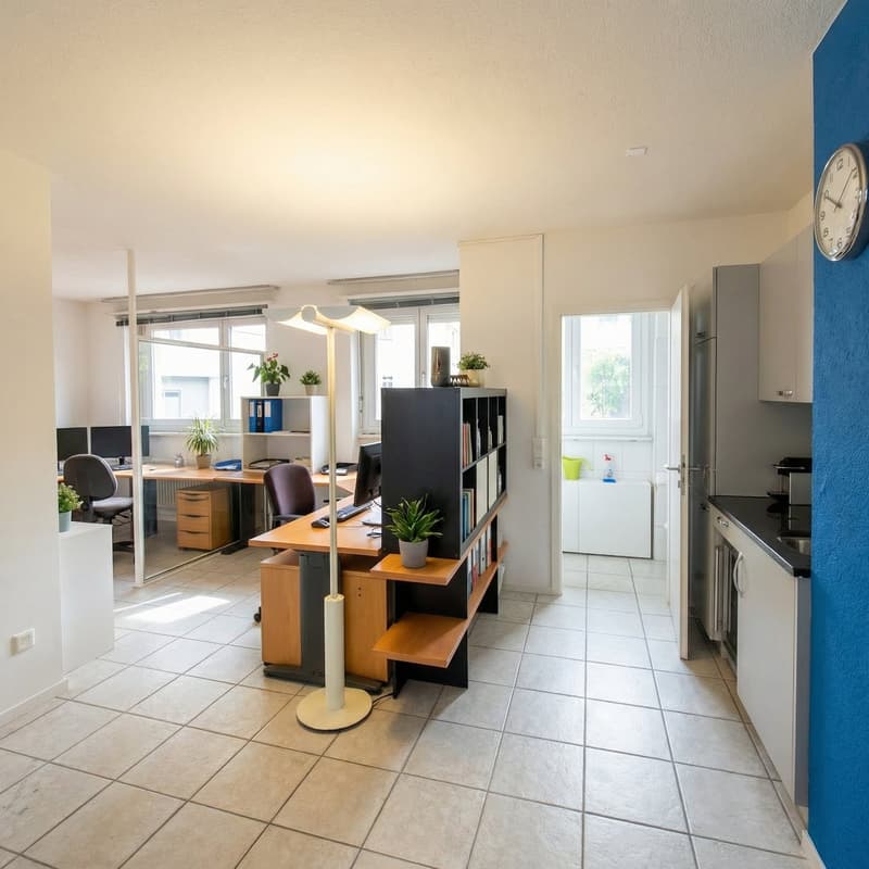 Office space with two desks, wooden floor, light brown walls, two monitors, office chairs, bookshelf, plants, lamp, radiator