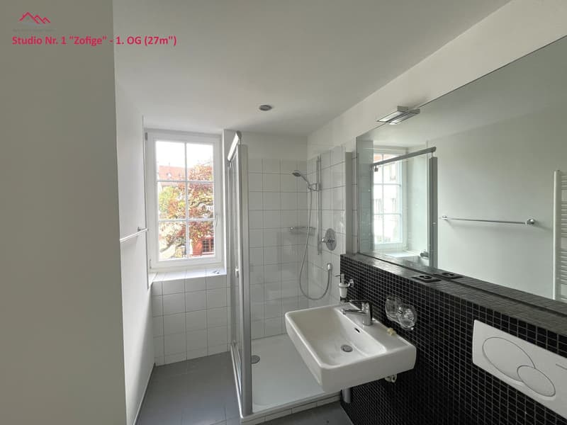 modern white bathroom, with walk-in shower, sink, and mirror, small window