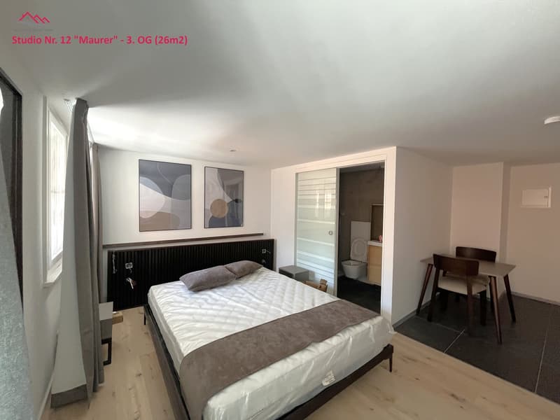 Bedroom: bed, nightstand, chairs, desk, window, curtains, paintings, radiator