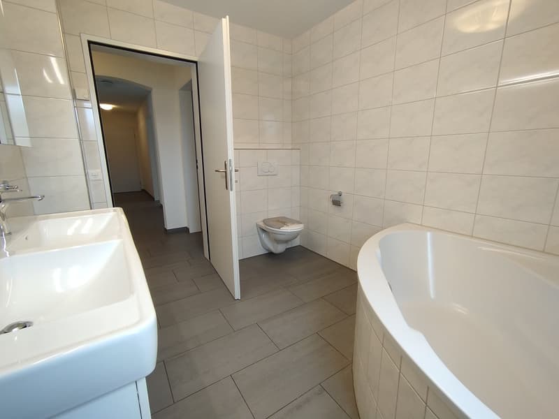 tiled walls, toilet, bathtub, sink, mirror, wooden floor