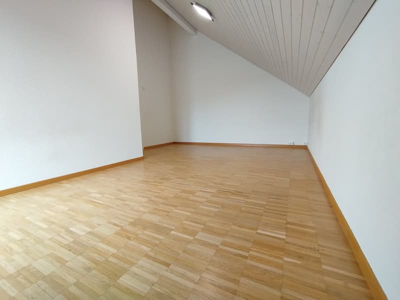 spacious empty room, hardwood floors, white walls, sloped ceiling