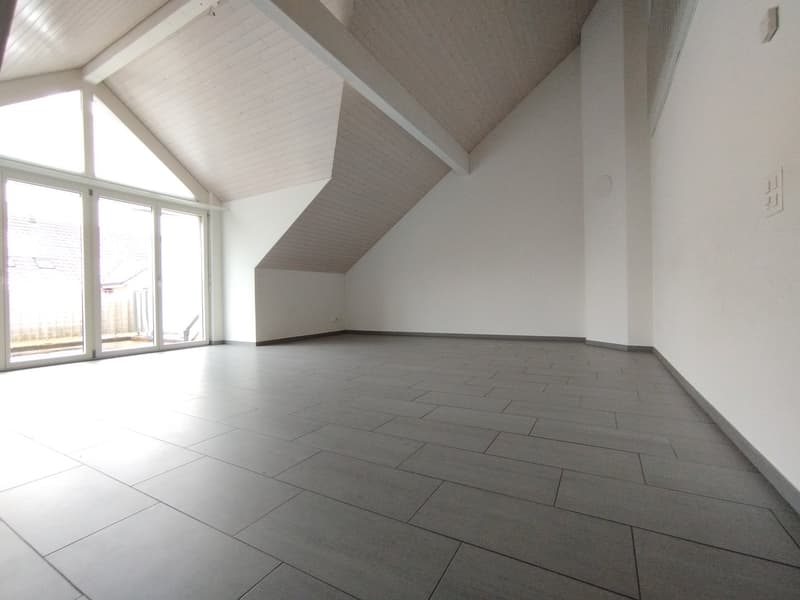 large open room, white walls, large window, gray tile flooring, empty