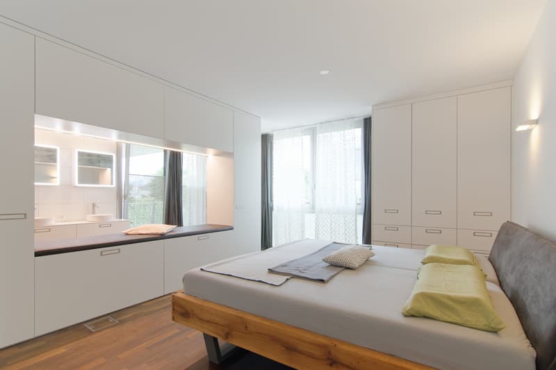 Schlafzimmer mit Einbauschrank und halboffenem Bad