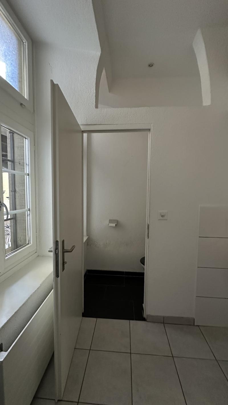 white walls, white tiles, window with bench, toilet