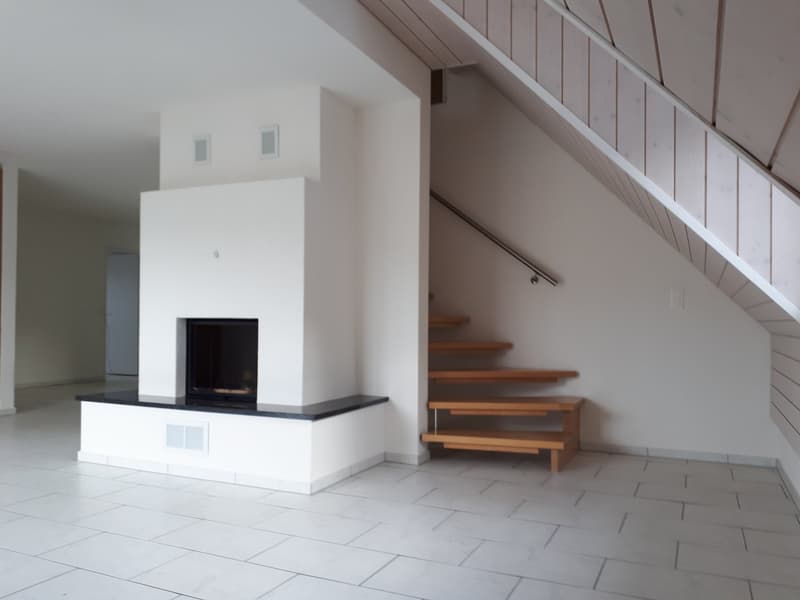 £Wohnzimmer mit Cheminée und Aufgang zum OG